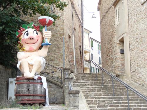 a statue of a person sitting on top of a barrel at Affittacamere Rooms Di Matteo in San Paolo di Iesi