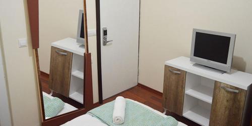 a room with a mirror and a tv on a desk at Dilara Hotel Pansiyon in Antalya