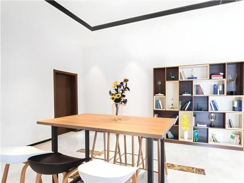 una sala da pranzo con tavolo, sedie e libreria di Borrman Hotel Changsha Wuyi Square Yingbin Road Metro Station a Changsha