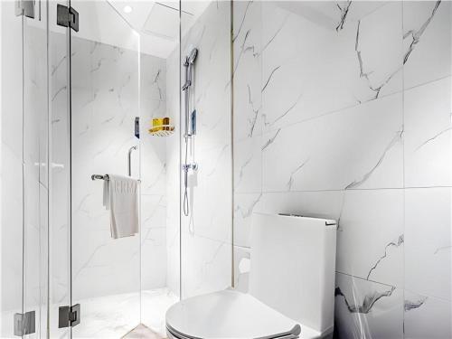 un bagno bianco con wc e doccia di Borrman Hotel Changsha Wuyi Square Yingbin Road Metro Station a Changsha
