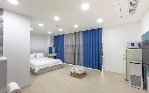 Un dormitorio con una cama y un frigorífico. en 안목을높이다 펜션, en Kyŏnso