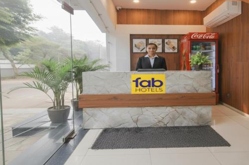 アムリトサルにあるFabHotel Springの店の窓の後ろに立つ男