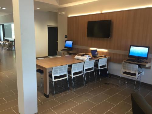 a conference room with a table and two computers on a wall at Microtel Inn & Suites by Wyndham Ocean City in Ocean City