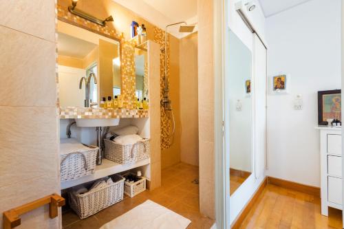 Villa Giasemi في سبيتسيس: حمام مزود بحوض ومِرآة