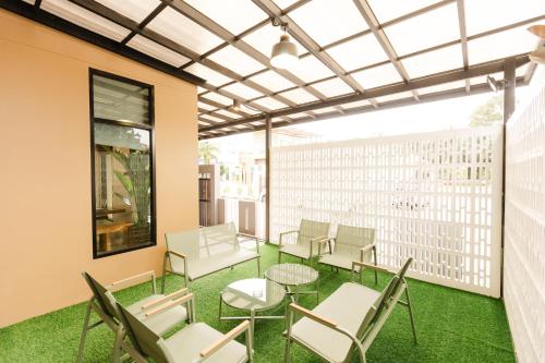 a patio with chairs and tables on a balcony at La Villa Pool Krabi in Ban Khlong Chi Lat