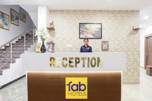 a woman standing at a reception desk in a building at FabHotel Duke Inn in Bhopal