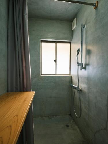 a shower in a bathroom with a window at 湊庵錆御納戸-so-an sabionand- in Higashiizu