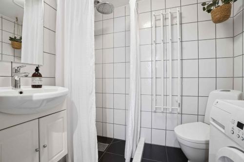 Un baño blanco con inodoro y lavabo. en Beautifull 2-Room Apartment With Sea View, en Sandvig