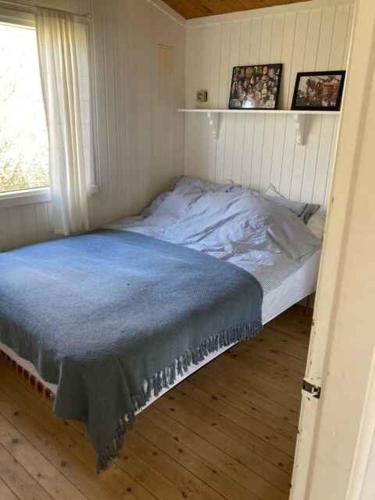 a small bedroom with a bed with a blue blanket at Lovely Holiday Home With Annex And Garden in Dronningmølle