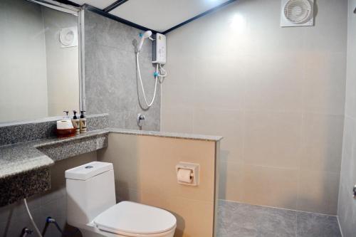 a bathroom with a shower with a toilet and a sink at Lanta IL Mare Beach Resort in Ko Lanta