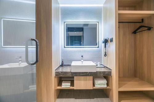 苏州Green Tree Inn Suzhou Wujiang East Tai Lake Tourism Resorts的浴室里有洗手池和镜子