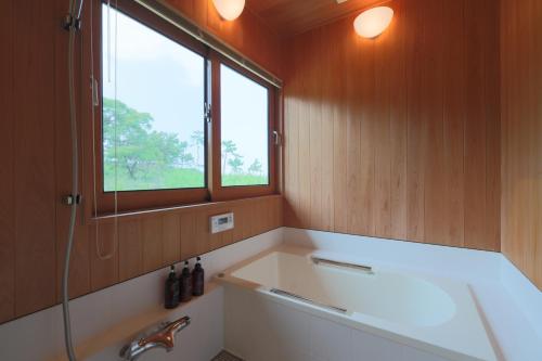 a bathroom with a tub and a sink and a window at New OPEN！ Luxury Seaside Villa 神湊　駐車場無料　海辺の別荘　 in Kōnominato
