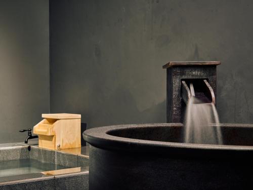 a water fountain in a room with at KONJAKUSO OSAKA TSUTENKAKU MUSHIBUROYA Sauna Villa in Osaka