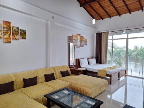 una sala de estar con un sofá y una cama en Amber House Lanka, en Bentota