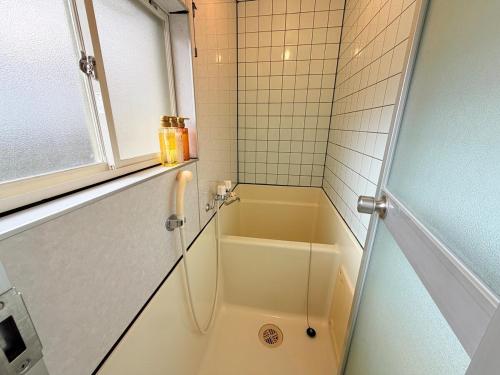 ein Badezimmer mit Dusche, Badewanne und Waschbecken in der Unterkunft ハイツ緑ヶ丘103 in Nagasaki
