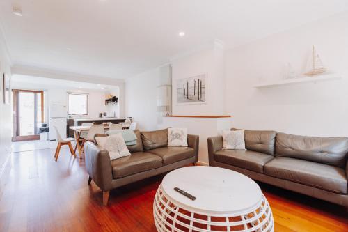 a living room with two couches and a table at Beach Holiday Apartments in Rye