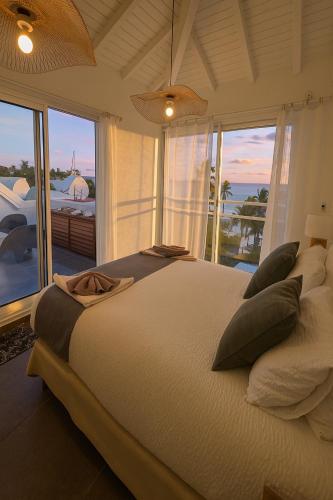 a bedroom with a large bed with a view of the ocean at Only4view - Rooftop & spa Sainte-Anne in Sainte-Anne