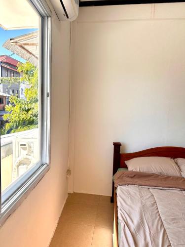 een slaapkamer met een bed en een raam bij Vientiane Semi detached house in Vientiane