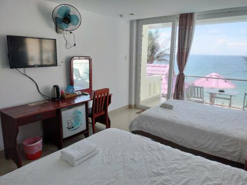 美奈Hai Yen Family Hotel的一间有两张床、一张桌子和一扇窗户的酒店房间