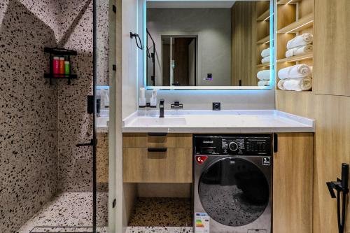 een badkamer met een wasmachine en een wastafel bij Apartments Akash - Tashkent City Residence in Tasjkent