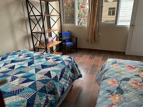 Casa Salo B2 في San Martín Zapotitlán: غرفة نوم بها سرير وكرسي ونافذة