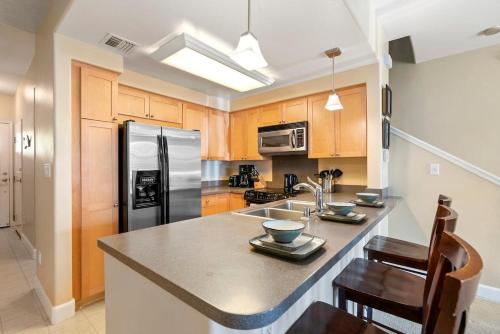 a kitchen with a sink and a refrigerator at Tranquil Oasis Resort Villa in Honokai Hale