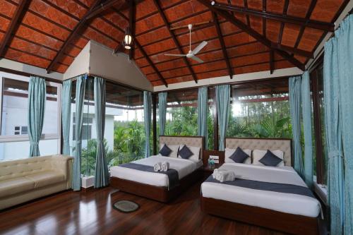 VastāraRG The Grand Haven Resort的带两张床和一张沙发的卧室