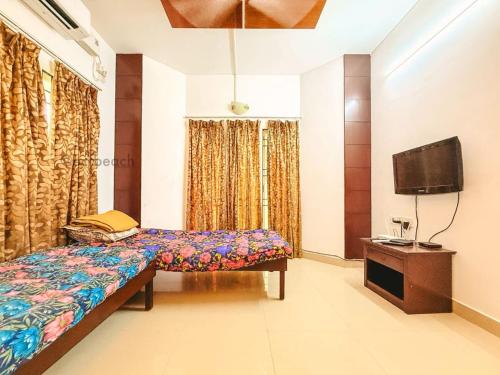 钦奈Royal Holiday Homes 4BHK premium Luxury Beach Villa, Uthandi的一间卧室，里面有一张床和一台平板电视