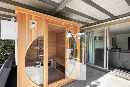 ein Holzhaus mit einer Glastür und einem Spiegel in der Unterkunft Aloha Bayside in Highett