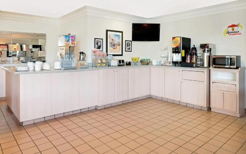 una cucina con mobili bianchi e un piano di lavoro di Super 8 by Wyndham Metropolis a Metropolis