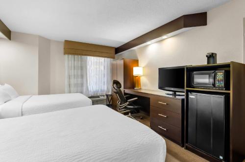 a hotel room with two beds and a flat screen tv at Sleep Inn Beaver- Beckley in Beaver