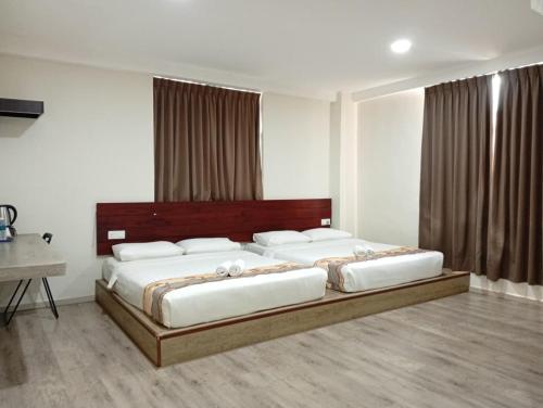 a bedroom with a large bed with white pillows at Mass Boutique Hotel in Mentekab