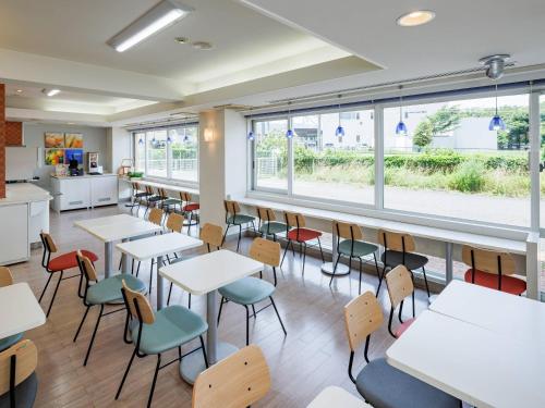 a classroom with tables and chairs and windows at Comfort Inn Shiojiri Kita Inter in Shiojiri