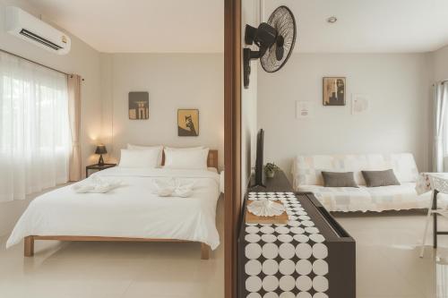 een slaapkamer met 2 bedden en een klok aan de muur bij Yada House s&s in Nai Yang Beach