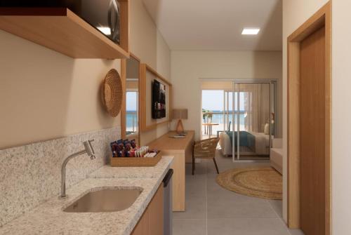 eine Küche mit einem Waschbecken und ein Zimmer mit einem Bett in der Unterkunft Wyndham Natal Pitangui Praia in Extremóz