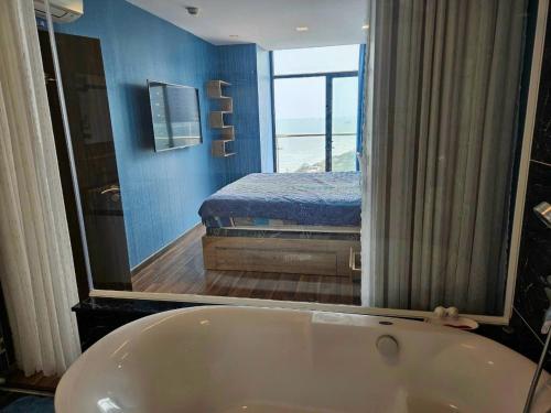 a bathroom with a tub and a bedroom with a bed at Trinh CSJ Tower 169 Thuỳ Vân in Vung Tau