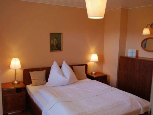 a bedroom with a white bed with two lamps at Holiday apartment with 1 bedroom in Aich