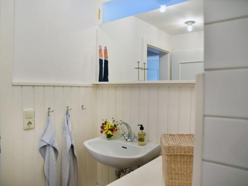a white bathroom with a sink and a mirror at Holiday apartment with 1 bedroom in Aich