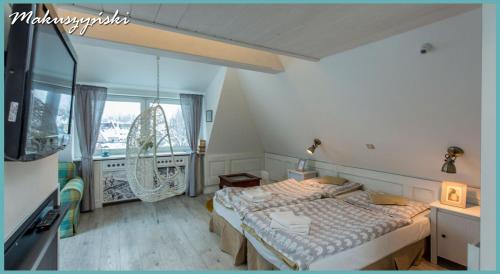 a bedroom with a bed and a large window at Willa Carlton in Zakopane