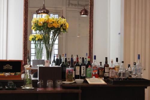 a bar with bottles of wine and a vase of flowers at Matildas Hotel Boutique in Santiago