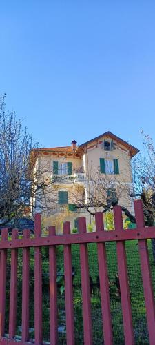 a red wooden fence in front of a house at b&b Casa Galletti in Busalla