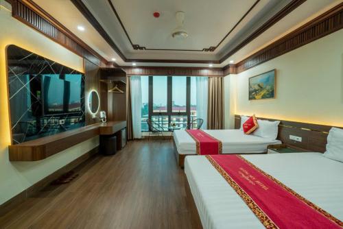 a hotel room with two beds and a television at Hương Sen Hotel in Ninh Binh