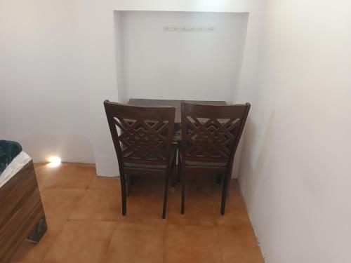 a dining room with two chairs and a table at Astha veg restaurant or guesthouse in Bareilly