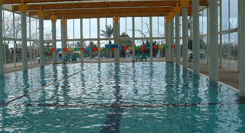 a swimming pool with water in a building at Alma in Caesarea