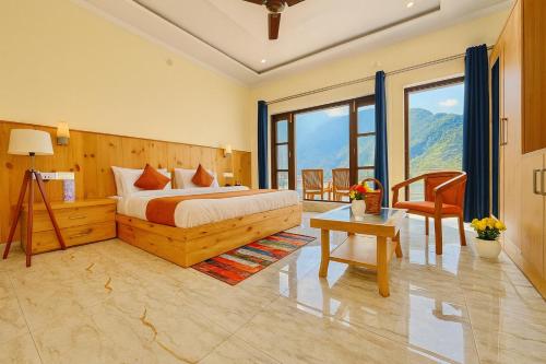 a bedroom with a bed and a table and some windows at Sitara Hotel & Resort in the lap of nature, Mussoorie in Mussoorie