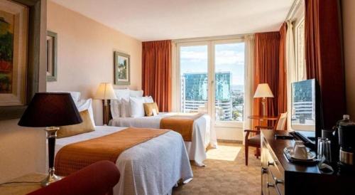 um quarto de hotel com duas camas e uma janela em Hotel Honduras Maya em Tegucigalpa