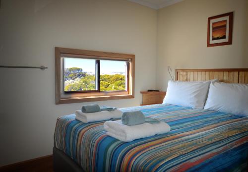 1 dormitorio con 1 cama grande y toallas. en Ceduna Shelly Beach Caravan Park en Ceduna