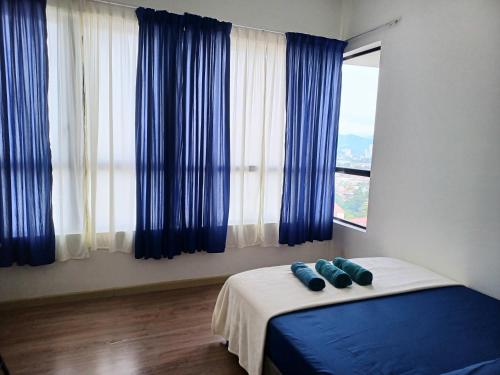 a bedroom with blue pillows on a bed with a window at Homestay MKH Boulevard 1 in Kajang