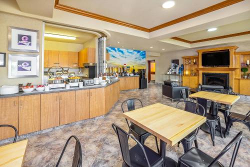 a room with tables and chairs and a kitchen at Clarion Pointe in Rimbey