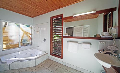 a bathroom with a tub and a sink at Eden House Retreat in Yungaburra